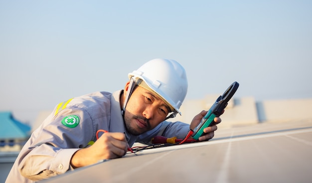 Engenheiro inspeciona painéis solares no telhado de uma casa moderna. conceito ecológico de energia alternativa.