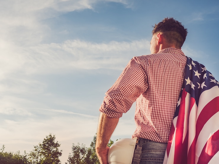 Foto engenheiro jovem, capacete de segurança branco e bandeira americana