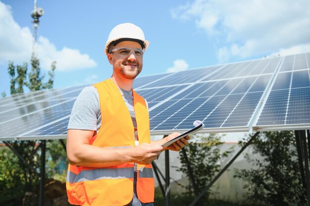 Engenheiro masculino em capacete protetor instalando sistema de painel solar fotovoltaico. Conceito ecológico de energia alternativa.