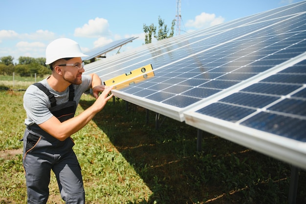 Engenheiro masculino em capacete protetor instalando sistema de painel solar fotovoltaico Conceito ecológico de energia alternativa