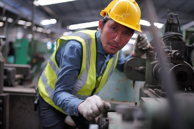 Engenheiro masculino metalúrgico industrial experiente operador técnico trabalhador em capacete rígido de segurança trabalhando em máquina de torno, homem profissional na oficina de fábrica de fabricação de tecnologia industrial