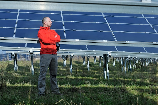 Engenheiro masculino no local de trabalho, indústria de plantas de painéis solares em segundo plano