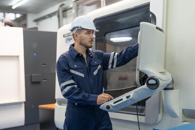 Engenheiro masculino usando máquina cnc de painel de controle de computador operando na fábrica