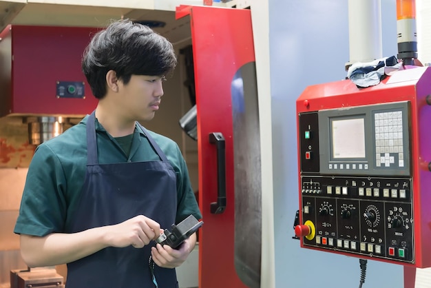 Engenheiro mecânico trabalhando na fábrica de máquinas-ferramentasAsian Torno Technician at WorkPessoas da TailândiaTrabalhador industrial bonito asiático operando máquina cnc