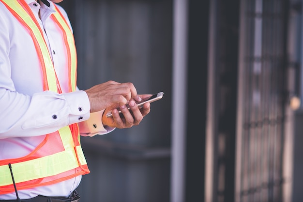 Engenheiro no capacete de segurança está usando um computador tablet em uma fábrica de indústria pesada