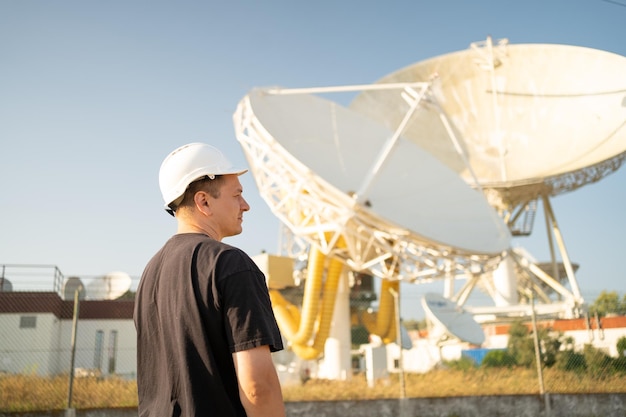 Engenheiro olhando telescópio de rádio astronômico baseado na terra