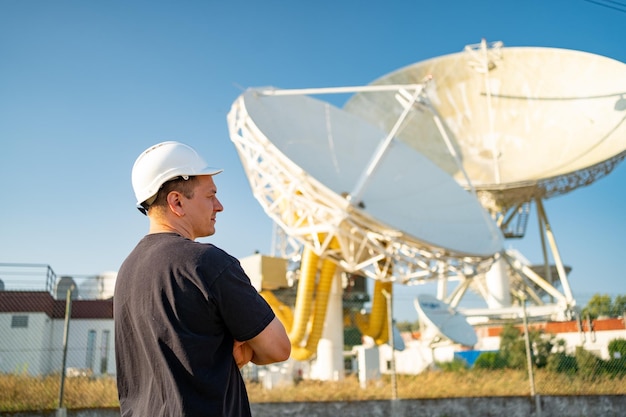 Engenheiro olhando telescópio de rádio astronômico baseado na terra