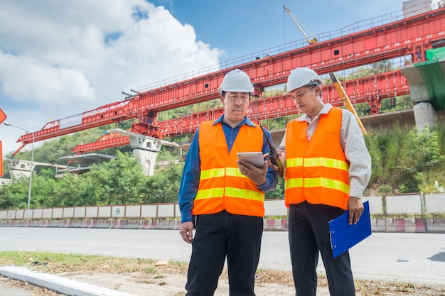 Engenheiro ou Arquiteto consultam sobre a Digital Tablet para supervisionar ou gerenciar o Projeto Rodovia ou Rodovia