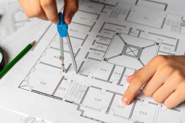 Engenheiro que esboça o projeto de construção em uma planta com um lápis b