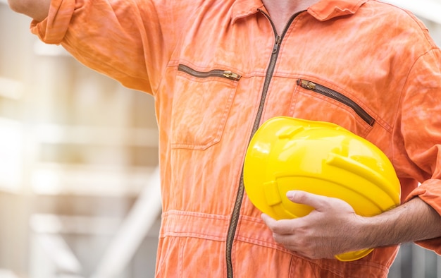 engenheiro segurando o capacete amarelo para trabalhadores edifícios de apartamento e construção