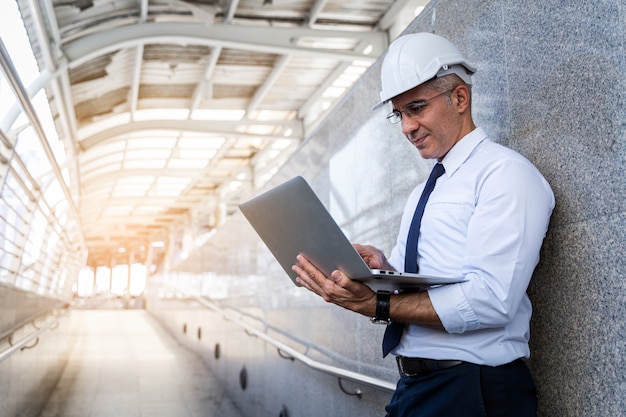 Engenheiro sênior que usa um tablet pc em uma fábrica no local de trabalho ao ar livre.