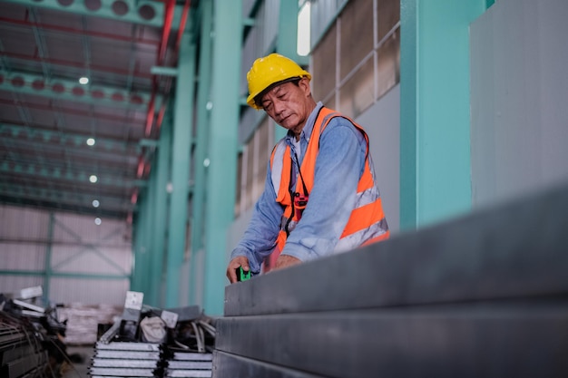 Engenheiro sênior trabalhando dentro do prédio de uma fábrica industrial