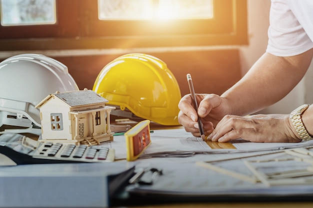 engenheiro trabalhando plano de inspecção esboçar no local de trabalho com luz do sol