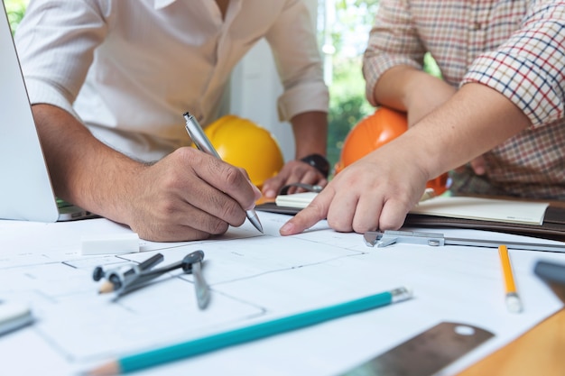 Engenheiros arquitetos e equipe do escritório agente imobiliário trabalhando com plantas