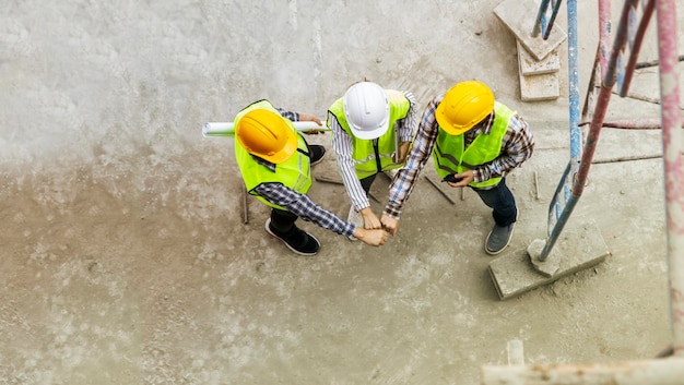 Engenheiros de construção trabalham juntos no canteiro de obras para o sucesso unindo forças e equipes