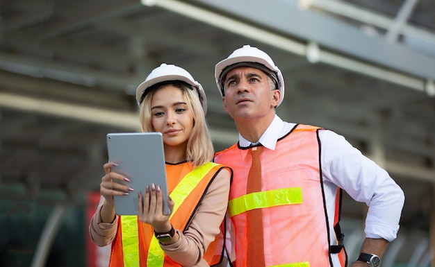 Engenheiros de construção trabalhando e verificando um novo projeto em um canteiro de obras