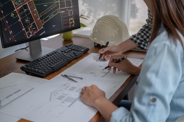 Foto engenheiros discutem um projeto enquanto verificam informações em um tablet em um escritório