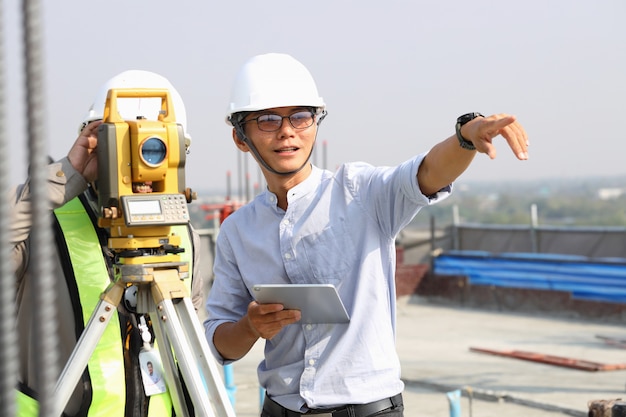 Engenheiros e funcionários estão inspecionando os edifícios usando o teodolito.