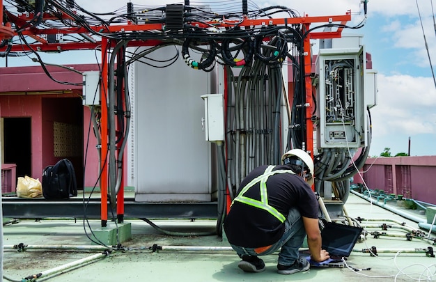 Engenheiros eletricistas inspecionam os sistemas elétricos no gabinete de controle do equipamento usado com 5G