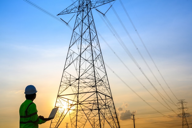 Engenheiros elétricos trabalhando e conversando com a estação de energia para ver o funcionamento do planejamento de geração de energia no pólo de alta tensão.