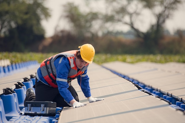 Engenheiros fotovoltaicos trabalham em fotovoltaicos flutuantes Inspeccionam e reparam o equipamento de painéis solares