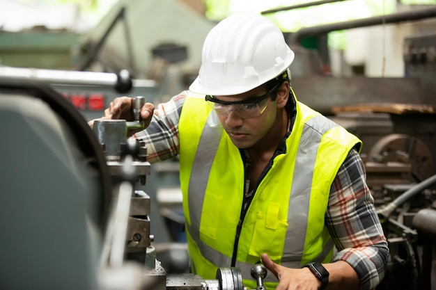 Engenheiros Industriais em Capacetes. Trabalho na Fábrica de Fabricação de Indústria Pesada. Trabalhador industrial dentro de casa na fábrica. Homem idoso trabalhando em uma indústria