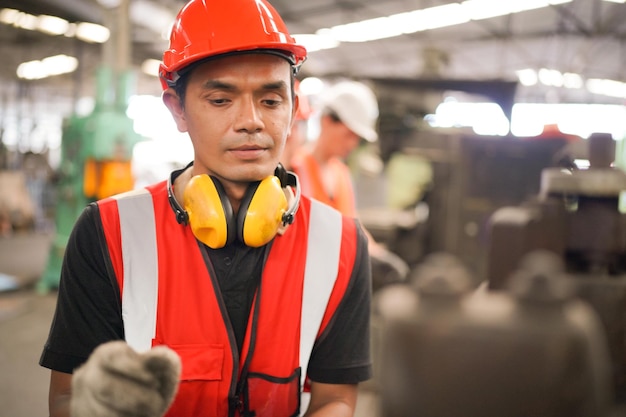 Engenheiros Industriais em CapacetesTrabalho na Fábrica de Fabricação da Indústria Pesadatrabalhador industrial dentro de casa na fábrica homem trabalhando em uma fábrica industrial