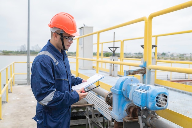 Engenheiros mecânicos de técnicos de manutenção de estações de água verificam o sistema de controle na estação de tratamento de água