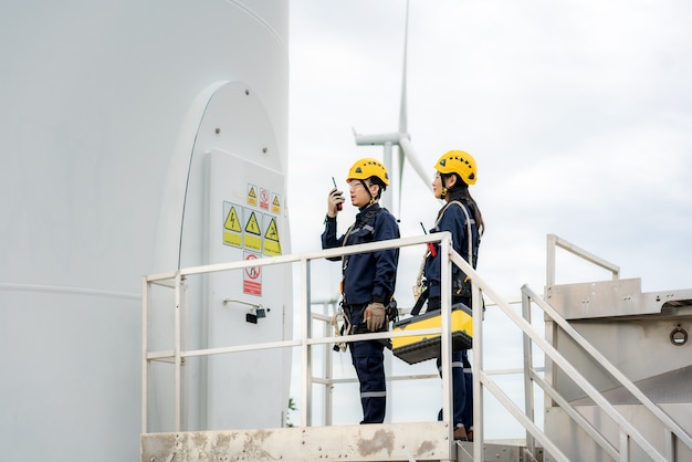 Engenheiros preparando e verificando o progresso de uma turbina eólica