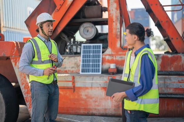 Engenheiros verificando o painel de células solares para operar o trabalhador inteligente da indústria de energia renovável