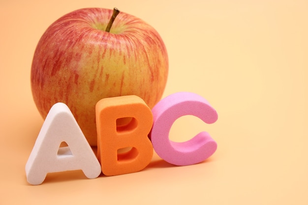 Englische ABC-Buchstaben neben Apfel. Fremdsprache lernen.