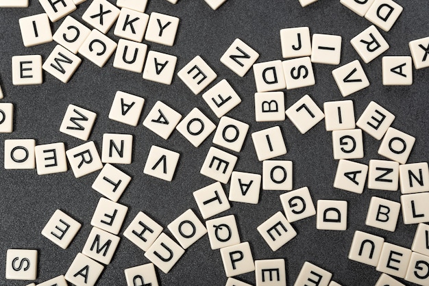 Englisches Alphabet aus quadratischen weißen Kacheln auf grauem Hintergrund Lernkonzept der englischen Sprache Scrabble-Spiel