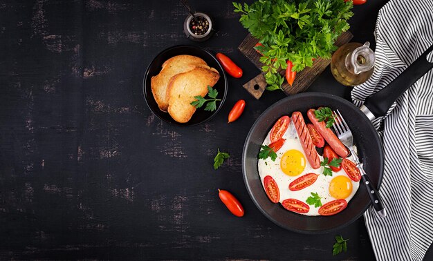 Englisches Frühstück mit gebratenen Eiern, Tomaten, Wurst und Toast