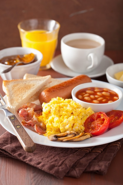 Englisches Frühstück mit Rührei, Speck, Wurst, Bohnen und Tomate