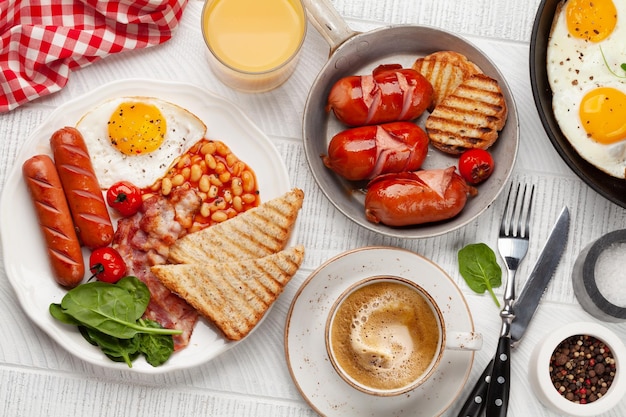 Englisches Frühstück mit Spiegeleiern, Bohnen, Speck und Würstchen