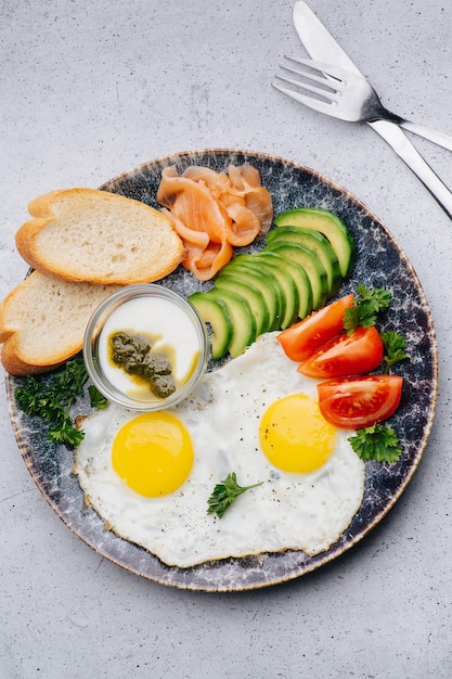 Englisches Frühstück mit Spiegeleiern, Tomaten, Gurken und Lachs Draufsicht