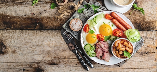 Englisches Frühstück. Spiegelei, Bohnen, Tomaten, Speck und Kaffee.