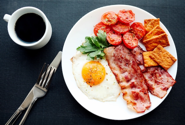 Englisches Frühstück - Spiegeleier, Kräuter, Tomaten, Speck und Cracker