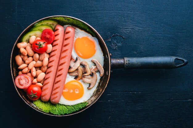 Englisches Frühstück Spiegeleier Würstchen Speck Bohnen Toast Tomaten Kaffeetasse auf Steintisch Draufsicht mit Platz für Ihren Text