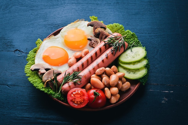 Englisches Frühstück Spiegeleier Würstchen Speck Bohnen Toast Tomaten Kaffeetasse auf Steintisch Draufsicht mit Platz für Ihren Text