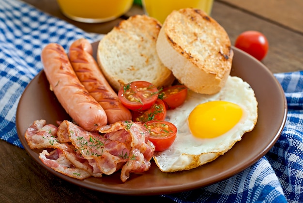 Englisches Frühstück - Toast, Ei, Speck und Gemüse in einer rustikalen Art auf Holzoberfläche