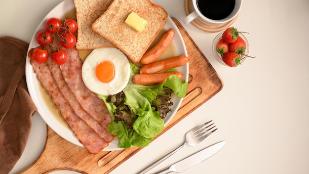 Englisches Frühstücksset mit Ei, Speck, Würstchen, Toast und Salat, serviert mit schwarzem Kaffee.