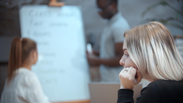 Foto englischunterricht in der klasse mit einer gelangweilten afroamerikanischen lehrerin schaut von der tafel weg