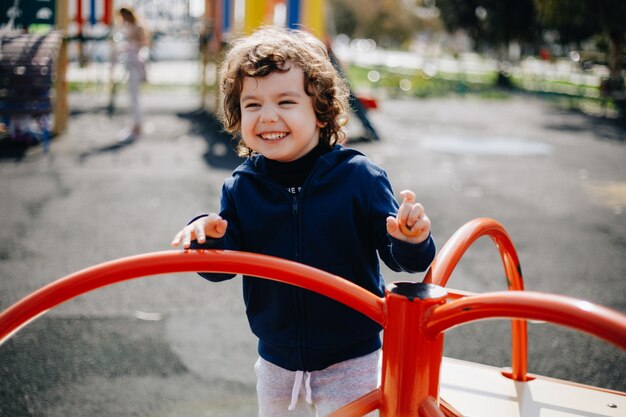 Engraçado bebê feliz fofo brincando no playground. A emoção da felicidade, diversão, alegria. Sorriso de uma criança.