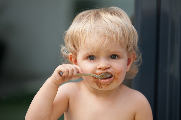 Engraçado bebê loiro comendo chocolate