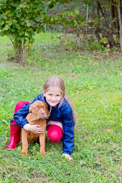 Engraçado cachorro Dogue de Bordeaux e uma menina Uma menina abraça seu amigo de quatro patas