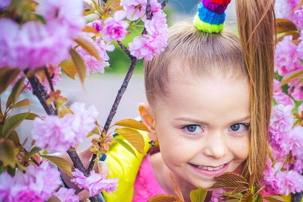 Engraçado e adorável retrato de colegial no jardim da primavera sorriso de primavera sorrindo criança feliz na moda multi