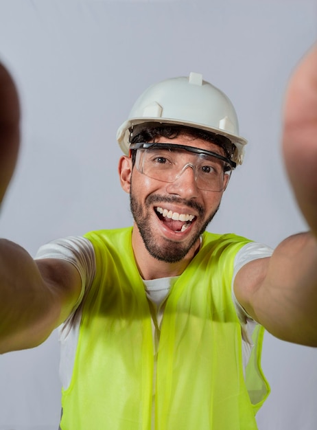 Engraçado engenheiro construtor tirando uma selfie isolado Engenheiro tirando uma selfie isolado Vista do engenheiro masculino tirando uma selfie isolado Engenheiro sorridente tirando uma selfie olhando para a câmera