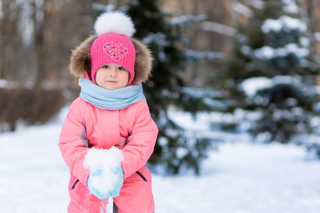 Engraçado menina criança brincando em bolas de neve. inverno jogo de inverno para crianças. Criança se divertindo na época do Natal