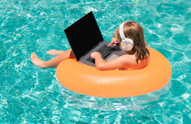 Engraçado pequeno empresário freelancer relaxando na piscina usando computador portátil na água de verão
